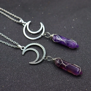 Detail of silver moon pendants with purple crystal hexagonal prisms and wire wrapping