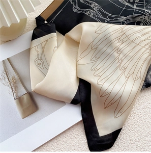 Vue détaillée du foulard carré en soie avec motif d'ailes bicolore beige et noir