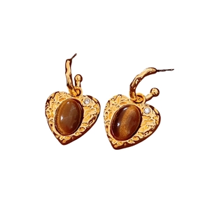 Orecchini a cuore vintage in oro con pietra in resina marrone e cristalli su fondo bianco