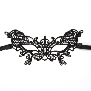 Close-up of black lace eye mask featuring intricate floral vine embroidery and silk ribbons