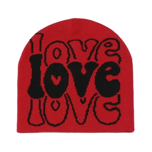 Detail view of red knit beanie featuring black LOVE jacquard lettering and soft texture