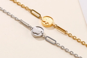 Detail of elegant gold and silver chain bracelets with hollow elephant charm pendants
