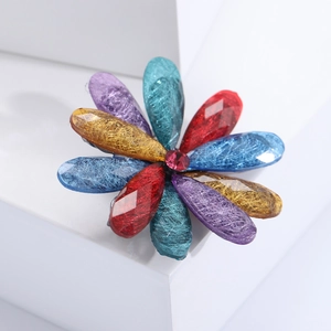 Macro shot of colorful acrylic flower brooch with resin petals and red stamen detail