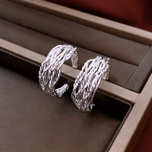 Vue détaillée de créoles tressées en argent plaqué or 18 carats sur un support en velours
