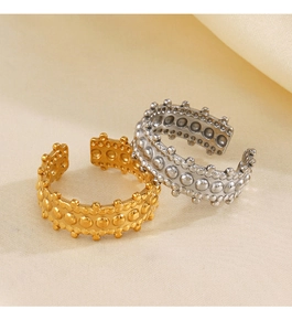 Detail of gold and silver irregular beaded rivet rings on soft white satin fabric