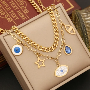 Close-up of gold double-layer bracelet with evil eye and star charms on jewelry box