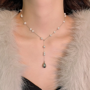 Détail du collier argenté avec perles roses et blanches et pendentif goutte noir
