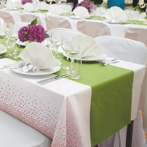 Elegant white disposable tablecloth with pink foil dots and matching green table runner