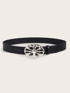 Detail of black leather belt featuring an ornate silver rhinestone buckle on a beige background