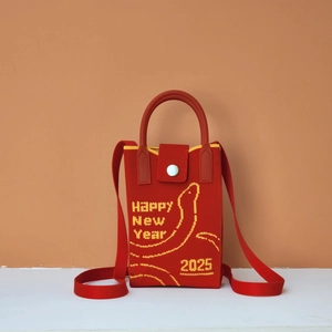 Macro detail of red knitted mobile phone bag with 2025 Happy New Year snake pattern
