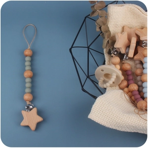 Handmade beech wood and silicone pacifier clip with star clamp on blue background