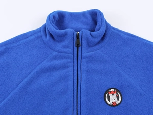 Detail of soft blue fleece jacket featuring a stand-up collar and circular chest embroidery