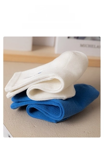 Detail of white and blue ribbed cotton crew socks neatly folded in a cozy layout