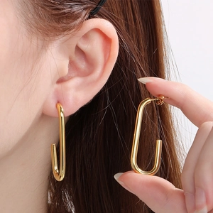Boucles d'oreilles minimalistes en acier titane doré en forme de U sur mannequin