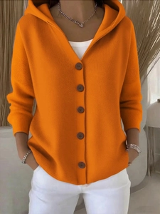 Detail der orangefarbenen Strickjacke mit Kapuze, Knöpfen und feinen Rippbündchen