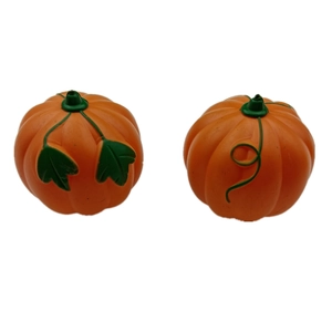Close-up of two small orange plastic Halloween pumpkins with green leaves and vine details