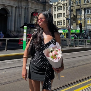 Vue lifestyle d'un haut licou vintage à pois avec de longs rubans fluides au cou