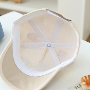 Detail showing the inner structure of a beige baseball cap with breathable mesh vents