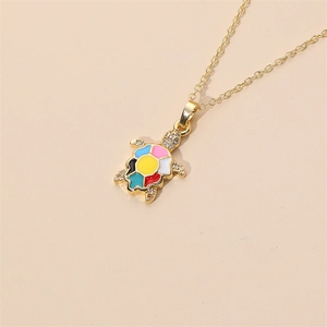 Detailed close-up of a gold-plated turtle pendant with colorful enamel and inlaid crystals