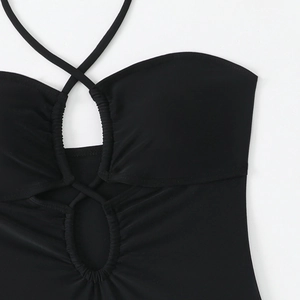 Détail d'un maillot de bain noir à licou avec découpe croisée et texture élastique