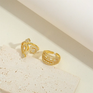 Irregular geometric 14K gold plated ring set with sparkling zircon on a stone surface