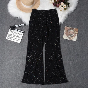 Close-up of black mesh flare pants with sparkling colorful rhinestones and sheer fabric