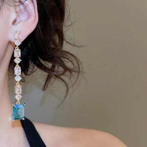 Macro shot of 18K gold plated drop earrings with sea blue zircon and clear crystals