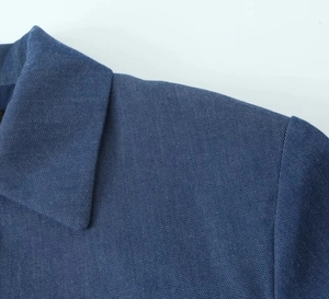 Close-up of deep blue twill fabric texture on a casual short jacket and pants set