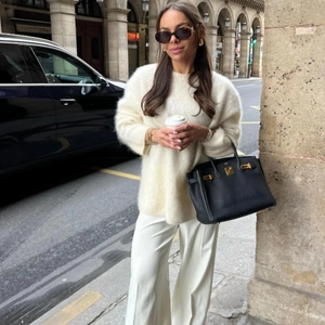 Look mode avec pull en tricot mohair crème et détail de sac à main en cuir noir