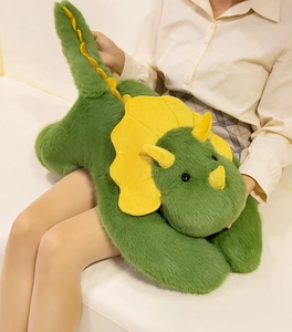 Close-up of soft green triceratops plush pillow held by model on home sofa