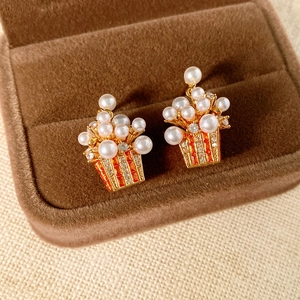 Macro shot of unique popcorn bucket earrings with white pearls and zircons in jewelry box