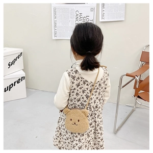 Close-up of cute plush bear shoulder bag with embroidery on fluffy lamb wool fabric