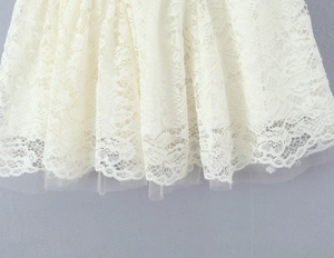 Detailed close-up showing the layered lace and mesh hemline of this white French dress