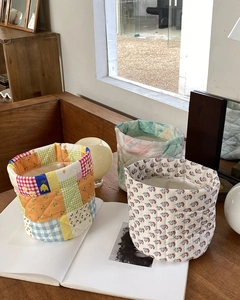 Detailed view of three quilted fabric organizers with various floral and patchwork patterns