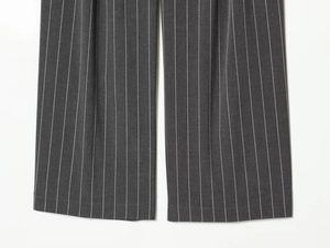 Détail du pantalon gris foncé à rayures montrant la texture du tissu et le motif vertical