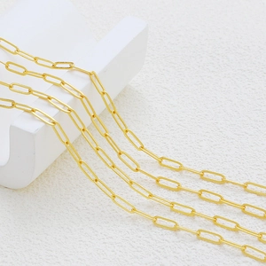 Detalle de cadena de clip ovalada bañada en oro de 18K sobre soportes geométricos