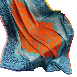 Élégant foulard en soie aux motifs floraux orange et bleu ciel, drapé délicatement