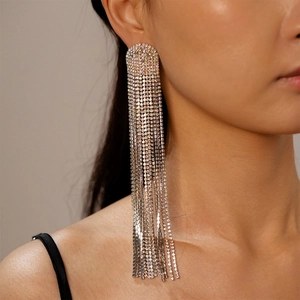 Close-up of sparkling multi-layer tassel earrings with silver rhinestones on a model