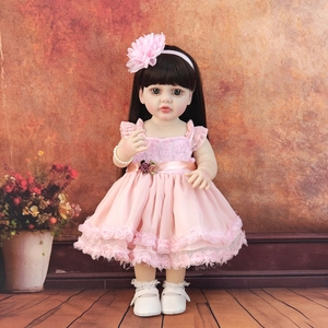 Close-up of a 55cm realistic reborn doll in a pink dress and floral headband