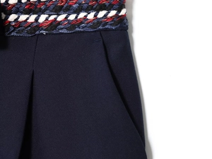 Détail de la ceinture tressée multicolore et de la taille plissée du short bleu marine