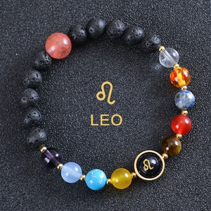 Close-up of Leo zodiac beaded bracelet with black lava stone and engraved central bead
