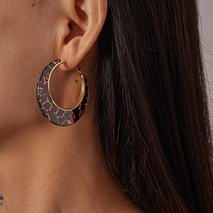 Close-up of tortoise shell resin hoop earrings with elegant gold inner plating