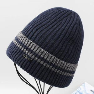 Detail showing the navy blue knit texture and silver metal Sport emblem on the beanie