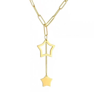 Minimalist gold tassel necklace with hollow and solid star pendants on paperclip chain
