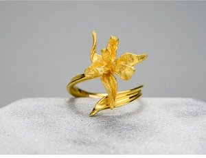 Detailed close-up of a matte gold iris flower ring with intricate petal textures