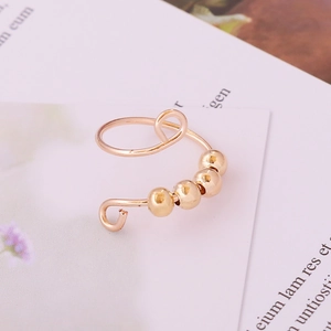 Detail of adjustable gold fidget ring with four rotatable metal beads for anxiety relief