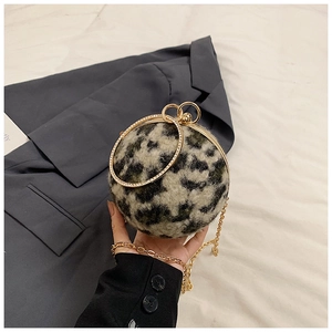 Detailed close-up of leopard print spherical handbag with gold handle and chain strap