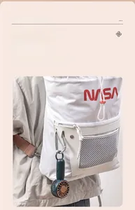 Detail of portable mini USB fan featuring integrated metal carabiner on a backpack