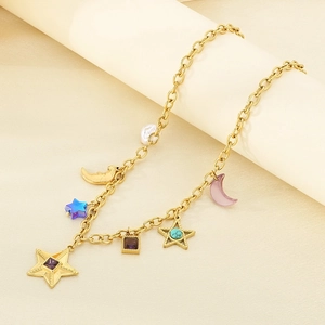 Détail d'un collier en acier inoxydable 18k avec étoiles, lunes et breloques colorées