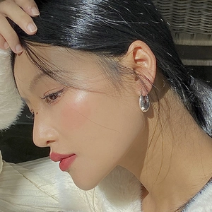 Boucles d'oreilles créoles épaisses en argent portées par un mannequin en vue de profil